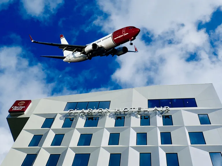 Forsidebilde til innlegget som viser et Strawberry hotell og et Norwegian fly som illustrasjon på samarbeidet de har om Spenn