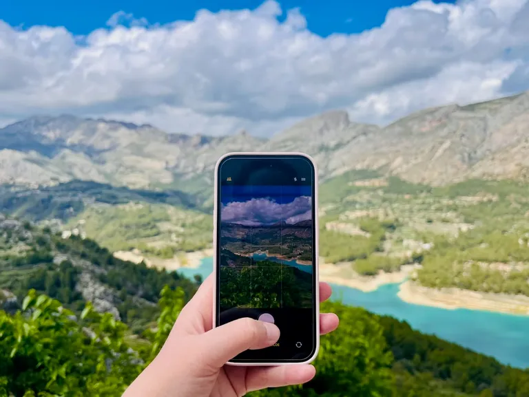Bilde av en mobiltelefon som tar et bilde av et fjellandskap